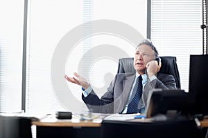 What do you mean we cant meet the deadline. A senior businessman taking a call at his desk.