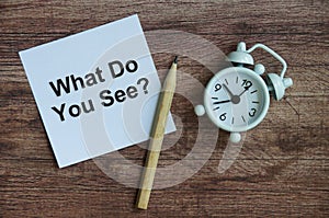 What do you see text on notepad with clock and pencil. photo