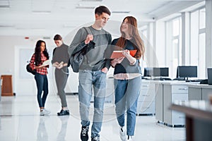 What do you think about it. Group of young people walking in the office at their break time