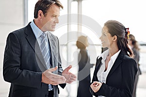 So...what do you think. two businesspeople talking in the lobby.