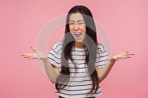 What do you want? Portrait of enraged irritated girl with brunette hair raising hands in questioning gesture