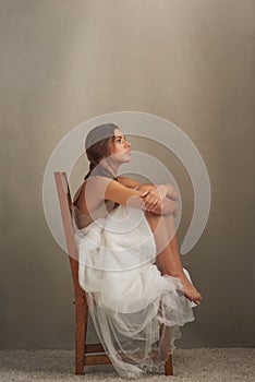 What goes on in that beautiful head...Studio shot of an attractive young woman looking thoughtful while sitting on a