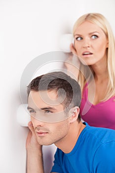 What is going on out there? Beautiful young couple eavesdropping photo