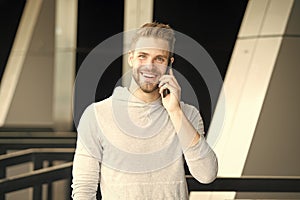 What great news. Man with beard call smartphone urban background. Guy happy smile use smartphone to communicate friends