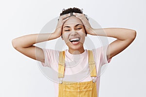 What great time to be alive. Portrait of carefree and joyful attractive young African American woman in yellow overalls