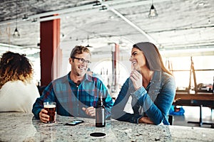 What a great way to start the weekend. a couple enjoying a drink at a bar.