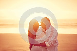 This is what happiness is. an affectionate mature couple embracing on the beach at sunset.