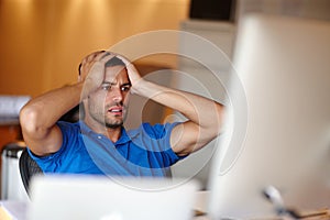 What have I done. Shot of an attractive young man looking worried at his desk.