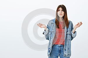 What the hell was that. Portrait of confused misunderstood good-looking girlfriend in denim jacket and striped blouse