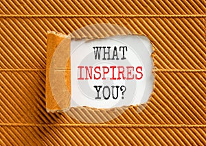 What inspires you symbol. Concept words What inspires you on beautiful white paper. Beautiful brown background. Business