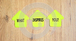 What inspires you symbol. Concept words What inspires you on beautiful yellow paper house. Beautiful wooden background. Business