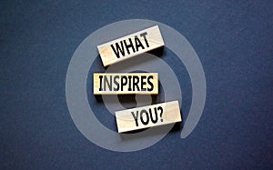 What inspires you symbol. Concept words What inspires you on wooden block. Beautiful black table black background. Business