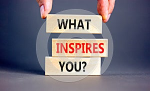 What inspires you symbol. Concept words What inspires you on wooden block. Beautiful grey table grey background. Businessman hand