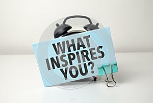 what inspires you is written in a blue sticker near a black alarm clock