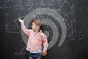 What a little genius. Studio shot of a young boy with a blackboard full of math equations.