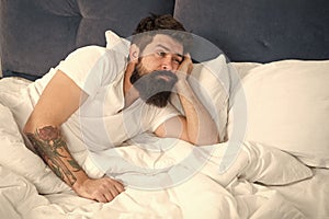 What a long night. Sleep disorders concept. Man bearded hipster having problems with sleep. Guy lying in bed try to