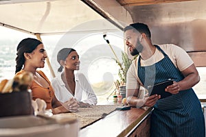 So what makes your smoothies so special. two friends ordering food from a food truck.