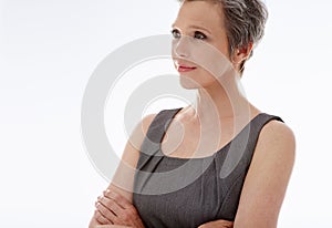 What the mind can conceive, it can achieve. A mature businesswoman looking away thoughtfully against a white background.