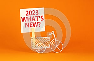 2023 what is new symbol. Wooden clothespin, white sheet of paper with words 2023 what is new. Miniature bicycle model. Beautiful