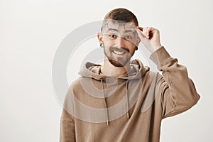 What nice surprise to see you near this copy space. Pleased handsome young european man taking off stylish glasses