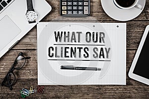 What Our Clients Say statement on notepad on office desk from ab