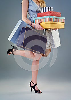 What recession. Studio shot of a happy young woman holding a selection of shopping bags and gift boxes.