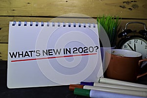 What`s New in 2020? write on Book isolated on wooden table