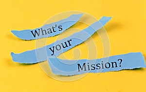 WHAT\'S YOUR MISSION text on a blue pieces of paper on yellow background, business concept