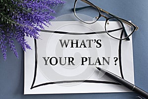 WHAT`S YOUR PLAN? - words on a white sheet against the background of glasses, pens and lavender
