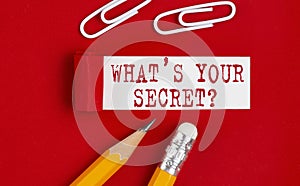 WHAT`S YOUR SECRET message written under torn red paper with pencils and clips, business concept