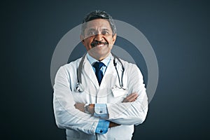 What seems to be troubling you. Studio portrait of a confident mature doctor against a gray background. photo