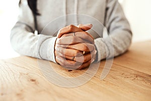 What should I do next. an unrecognizable businesswoman sitting at her desk alone with her hands together.