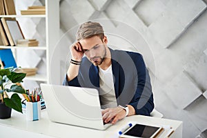 Thoughtful male working in business center photo