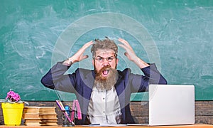 What stupid thought. Man bearded teacher aggressive expression sit classroom chalkboard background. Unpleasant wonder