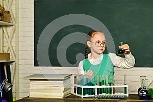 What is taught in chemistry. Chemistry science. Child in the class room with blackboard on background. Child from