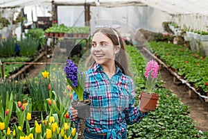 what to choose. happy teen girl florist in greenhouse. spring and summer. planting pot plants.