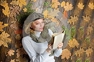 What to read in autumn book list. She likes detective genre. Girl blonde lay wooden background with leaves. Woman lady