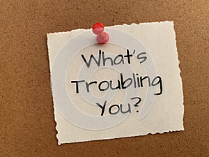What is troubling you text on white notepad. photo