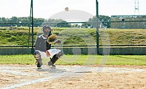 What a well timed catch. Full length shot of a young baseball player waiting to catch a ball during a match on the field