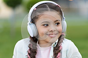 What a wonderful life. Happy girl wear headphones. Little music fan. Little child listen to music outdoor. Happy little