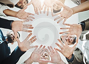 This is what working hands look like. Low angle shot of a group of cheerful businesspeople forming a huddle with their