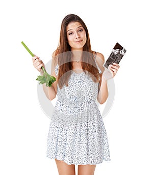 What would you do. An attractive young woman deciding between a stick of celery and a slab of chocolate.