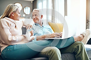 What would you like me to browse for. mature couple using a laptop on the sofa at home.