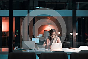 This is what you call a passion for your work. a businesswoman using a laptop at her desk during a late night at work.