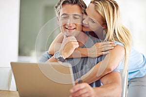 What you looking at. a happy mature couple using a laptop at home.