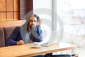 What you say? Interesting handsome young adult man freelancer in casual style sitting in cafe and talking with his friend in