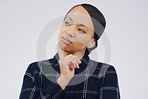 What are you thinking about. Studio shot of a young woman looking thoughtful against a gray background.