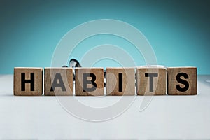 What is your habits? Sign with the word habits on white desk in a blue