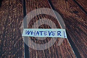 Whatever write on a sticky note Isolated on wooden table background