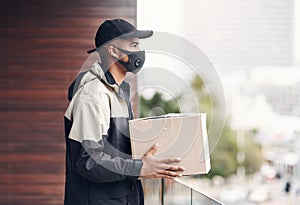 Whatever your location, hell get your delivery to you. a masked young man delivering a package to a place of residence.